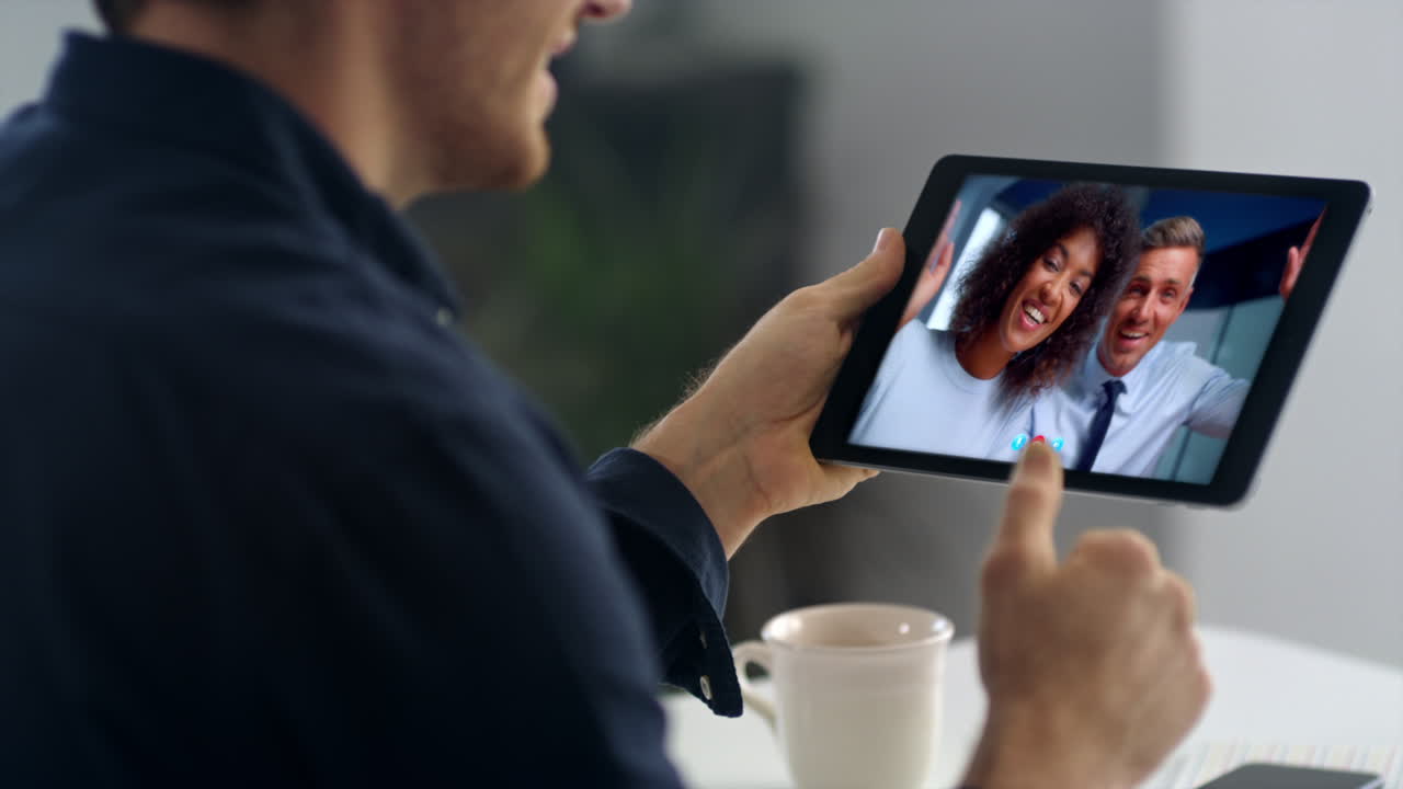 Primo piano di un team in ufficio che chatta sul web tramite videochiamata su tablet. Lavoratore da remoto