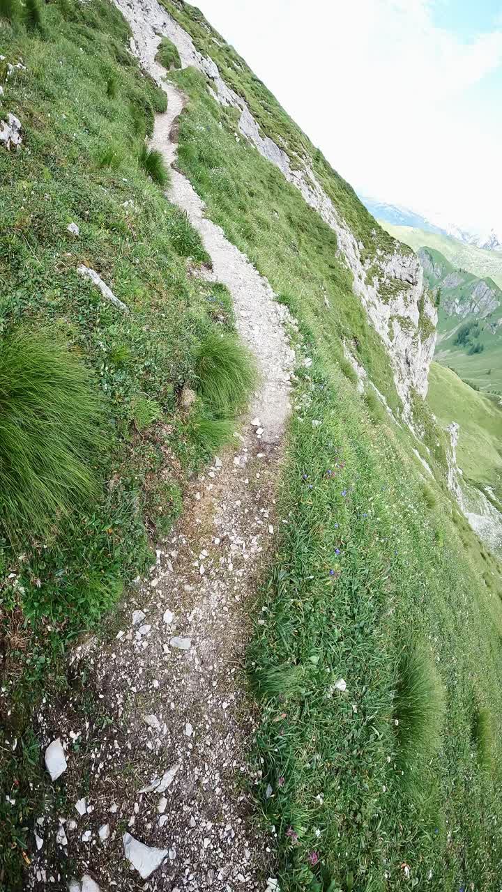 POV of man walking Dolomites trail and looking at massive mountain scenery