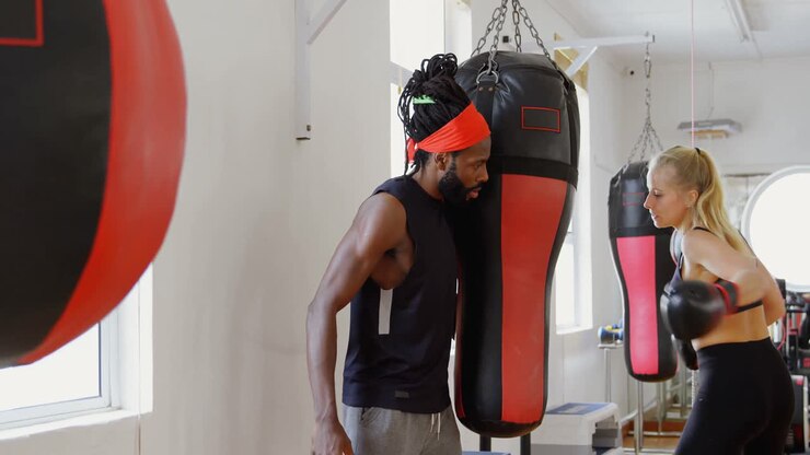 Pugile donna che si allena con la boxe in palestra 4k