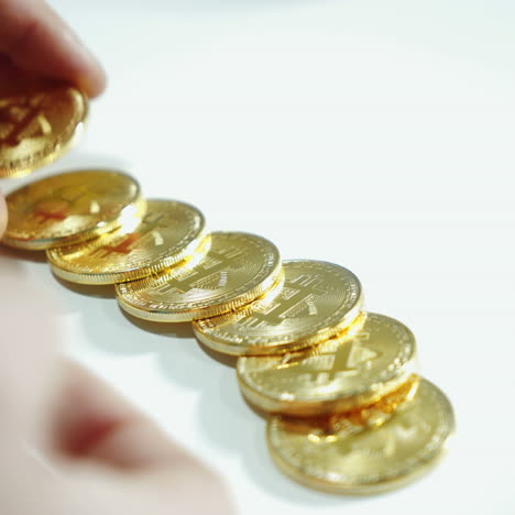 man considers coins bitcoin. cryptocurrency concept. gold bitcoin in the hand of man. digital symbol of the new virtual currency.