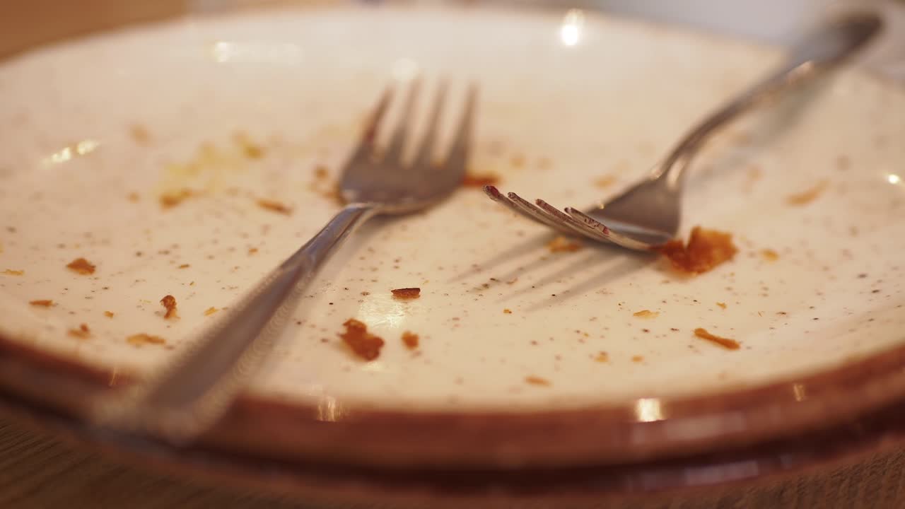 plato vacío con cubiertos y restos de comida