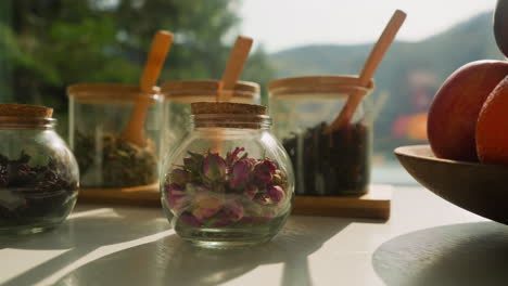 herbs arranged on white surface near window. various elements for tea preparation on dining table ready for usage. crafting wholesome beverage