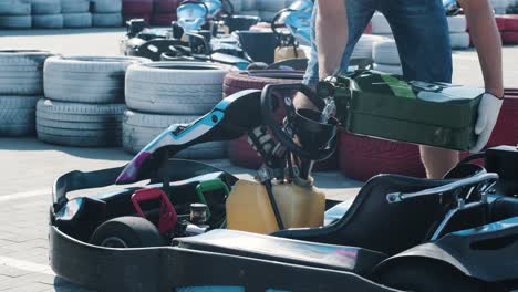 el mecánico del servicio de carreras de karts vierte combustible en el tanque.