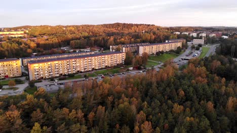 Vorortgebiet-Außerhalb-Von-Göteborg,-Schweden,-Luftbilddrohne,-Die-Bei-Sonnenuntergang-über-Dem-Wald-Am-Straßenrand-Rückwärts-Fliegt