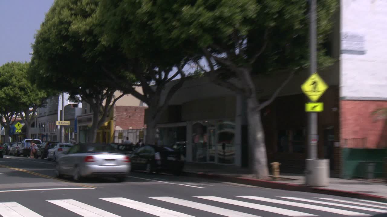 un automóvil viaja a lo largo de una calle en santa monica california como se ve a través de la ventana trasera en un ángulo 1