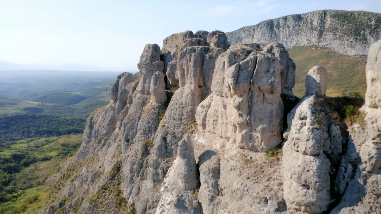 Dramatic Limestone Cliffs Rising Above Valley, Sunlit Aerial View Showcasing Textured Rock Outcrops And Steep