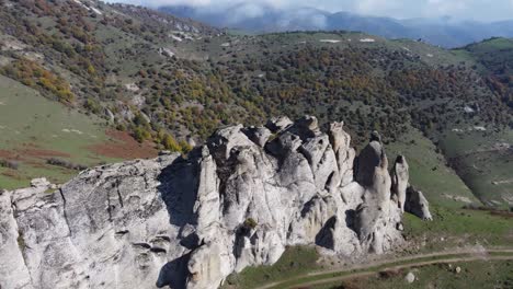 smooth granite outcrop atop rolling green mountain slope meadows