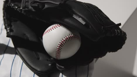 handheld close up studio baseball still life with ball catchers mitt and team jersey 1