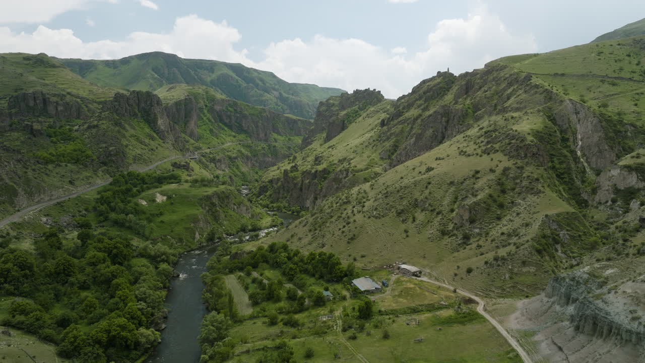Panorama del fiume Mtkvari che scorre tra le montagne con vegetazione verde in estate.