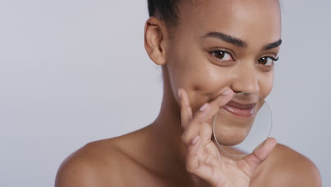 portrait attractive young african american woman holding magnifying glass smiling enjoying smooth healthy skin care sensual female with perfect complexion on white background