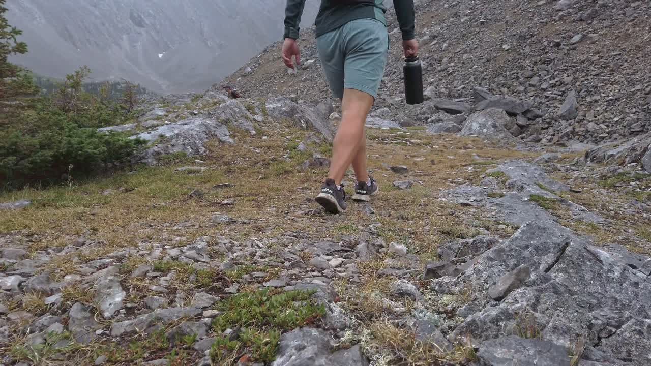 트레일을 걷고 있는 등산객의 발은 로키산맥 카나나스키스 앨버타 캐나다를 닫습니다.