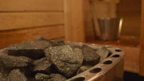 Depth-of-field-close-up:-Hot-sauna-rocks-steam-when-water-poured-on