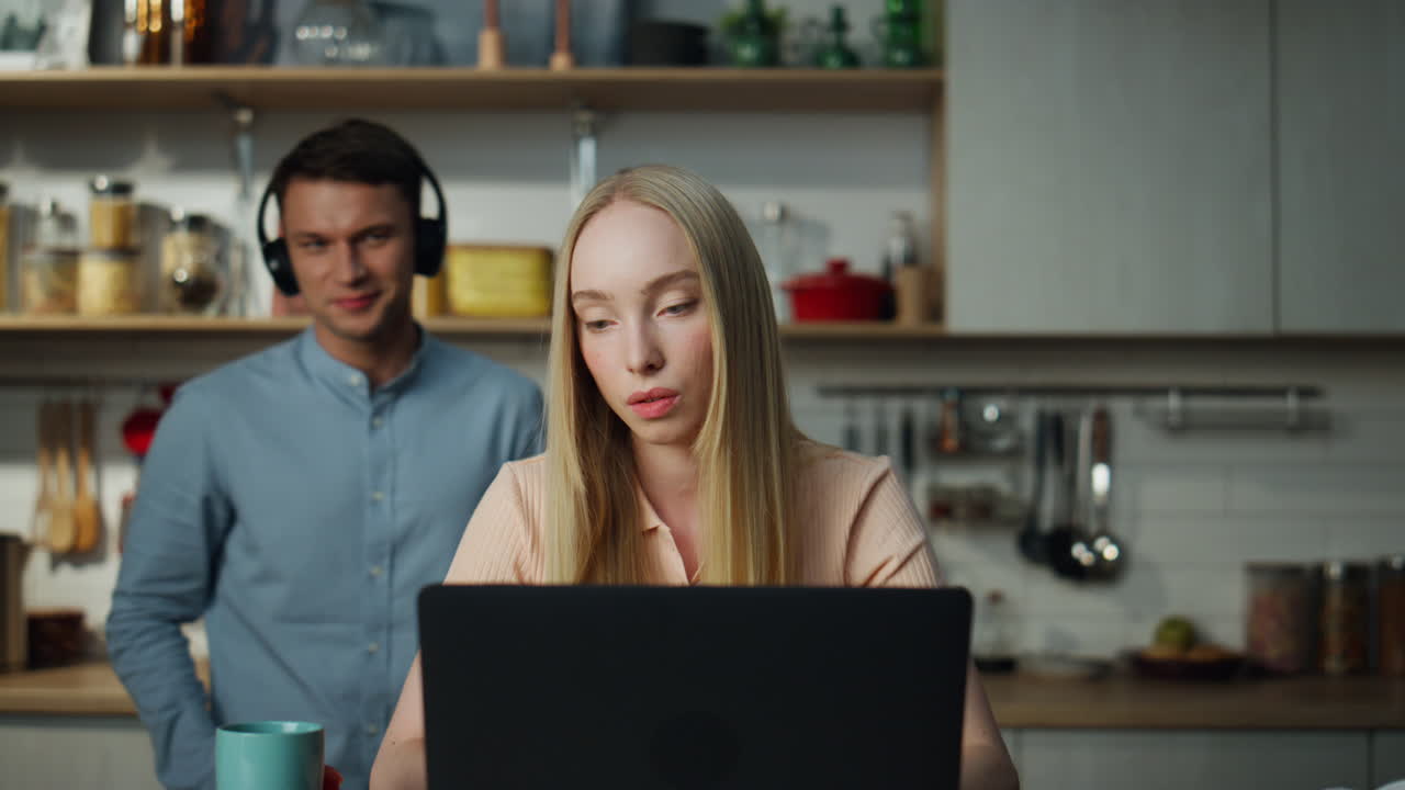 Donna d'affari che naviga in internet sul laptop. Uomo che ascolta musica sullo sfondo