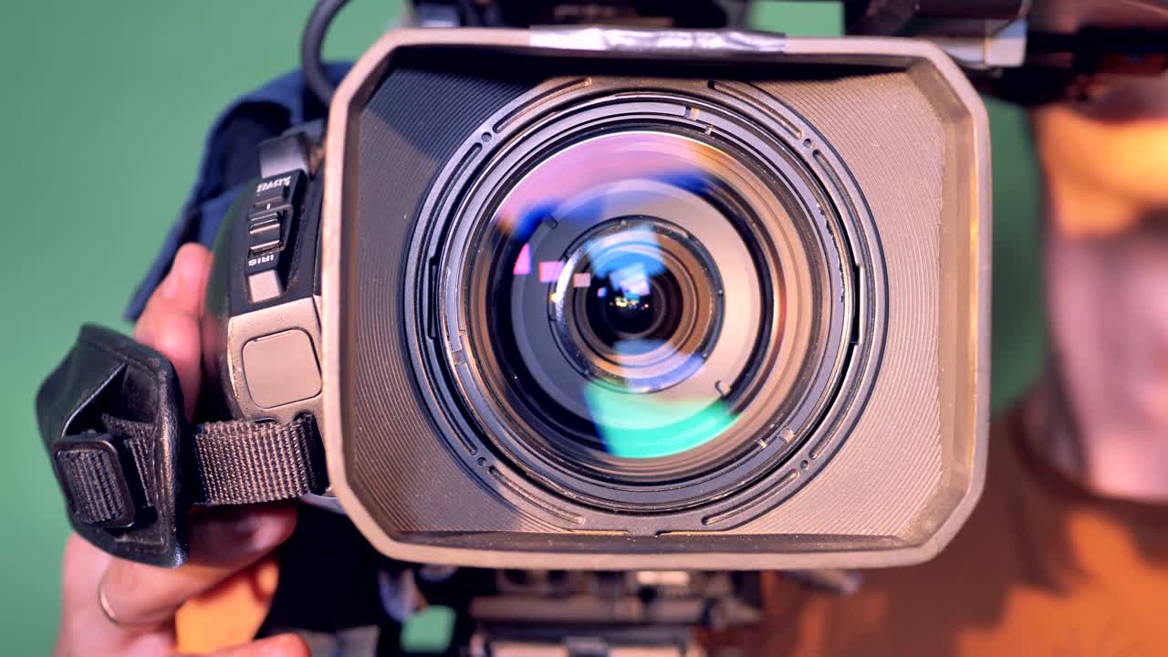 Camcorder is getting directed towards the viewer by a male operator