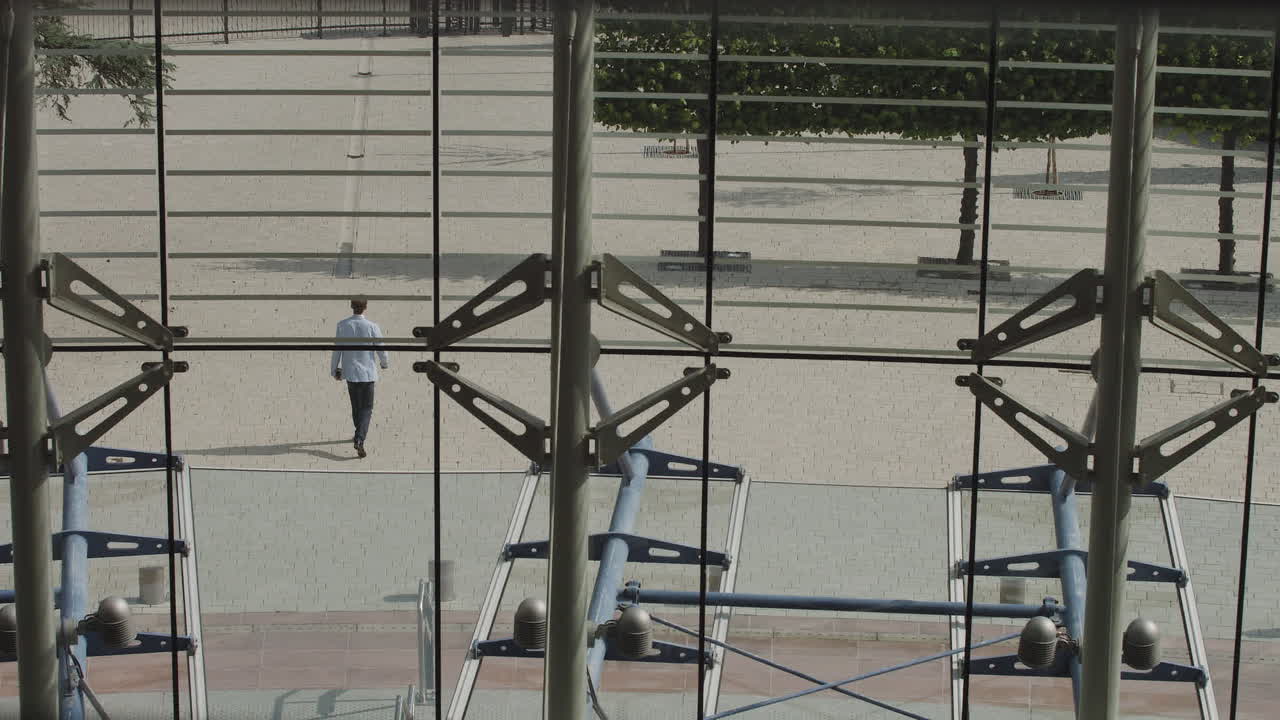 A nicely dressed man leaves a large office leaves work after a successful working day shooting from