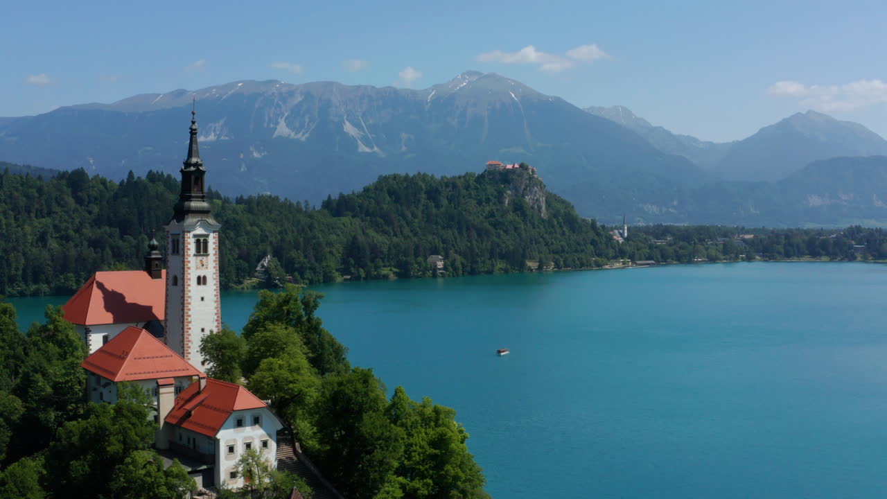 Campanile dell'antica chiesa nel Lago di Bled con vista sulla catena montuosa in Slovenia