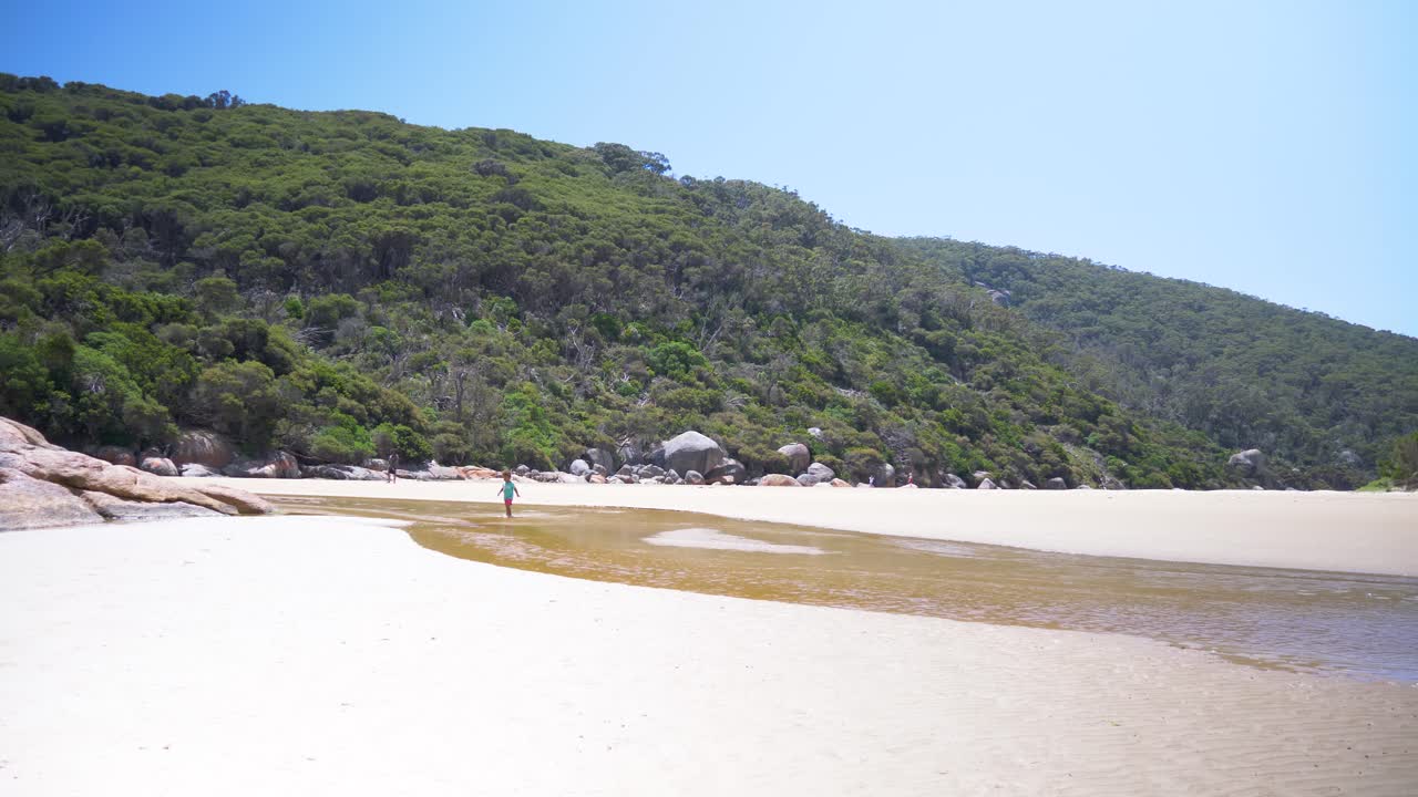 해변에서 강 입에서 실행하는 어린 아이