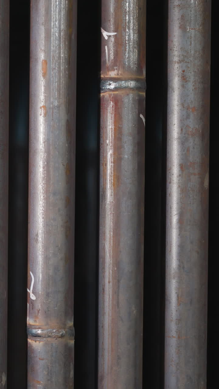 Steel pipes with welding seams in production factory storage closeup. Tubes for gas delivering and plumbing systems in metalwork plant workshop