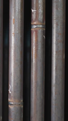 steel pipes with welding seams in production factory storage closeup. tubes for gas delivering and plumbing systems in metalwork plant workshop