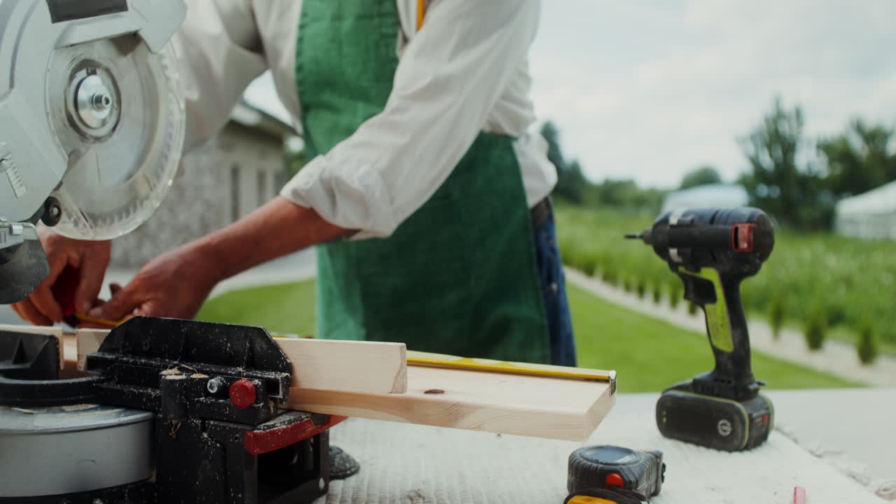 carpintero que trabaja al aire libre con herramientas eléctricas