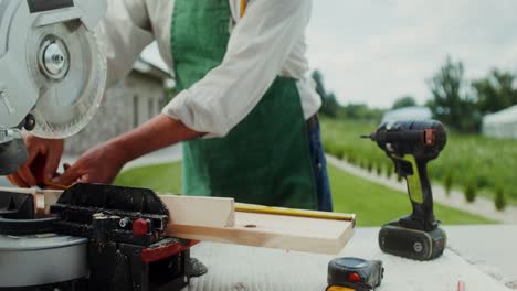 carpintero que trabaja al aire libre con herramientas eléctricas