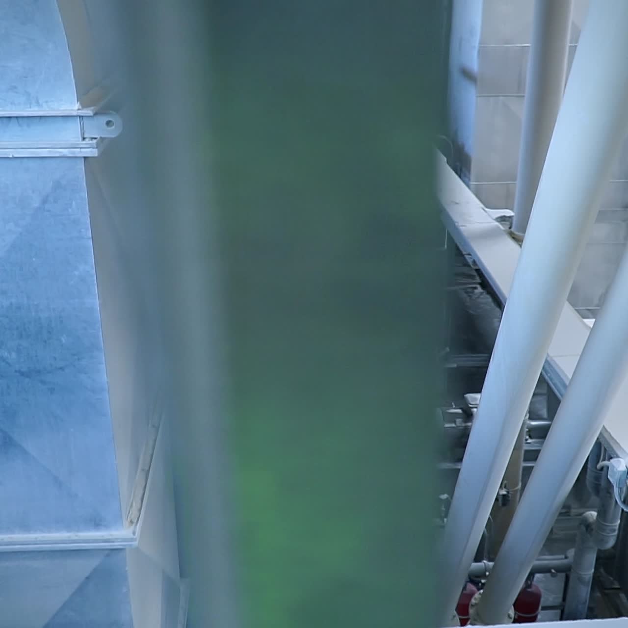Looking down at the conveyor belt transporting white clay for future processing. Modern kaolin factory