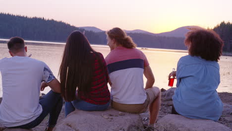 amigos disfrutando de la puesta de sol junto al lago.