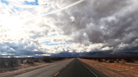 nubes oscuras sobre el desierto de mojave durante un viaje de un día desde el punto de vista del conductor