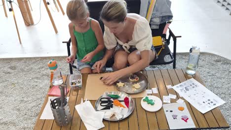 mother and daughter decorating cookies together