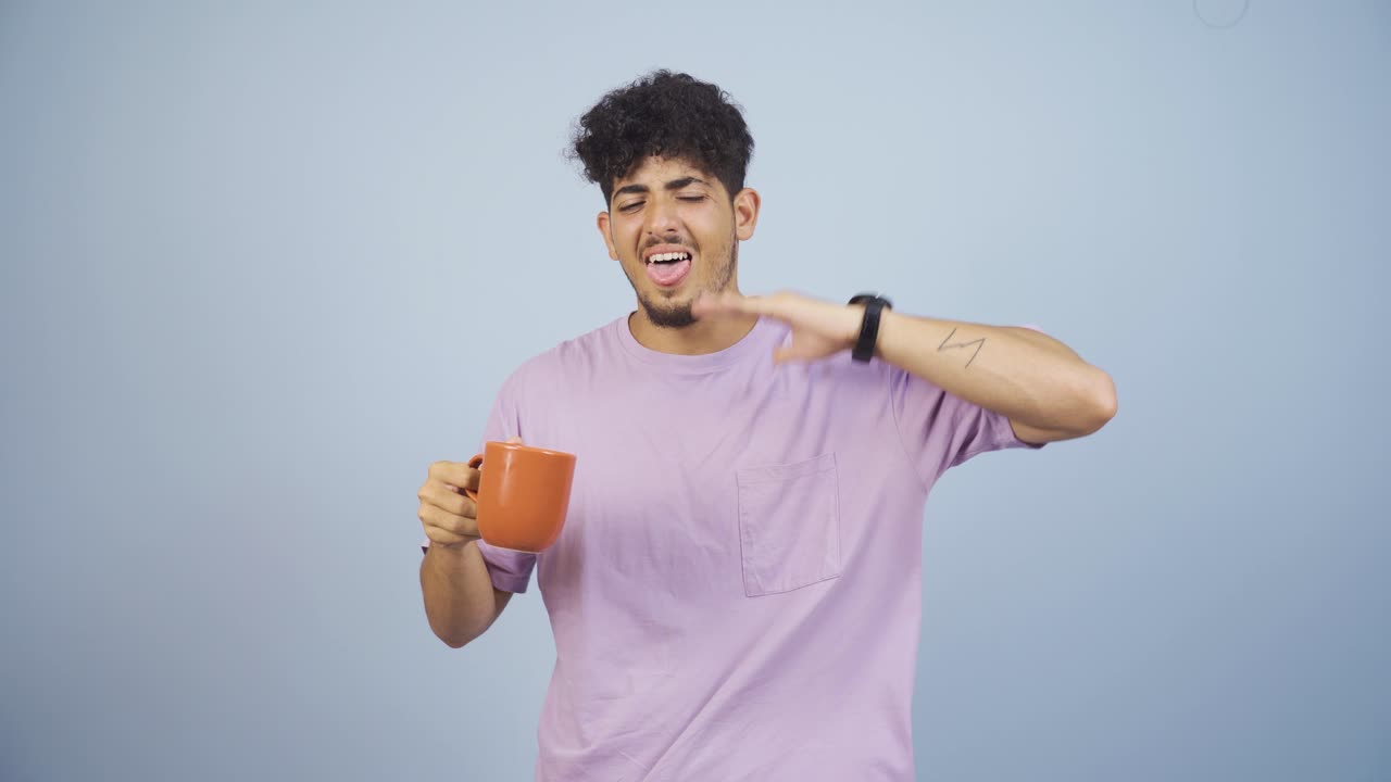 The man's mouth is burning from the hot drink.