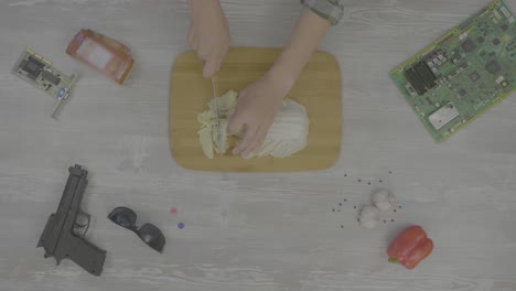 preparing cabbage while surrounded by electronics and other items