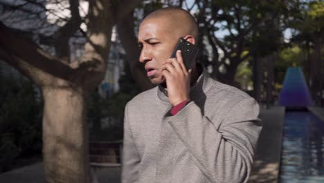 Serious-young-man-talking-by-cell-phone-outdoor