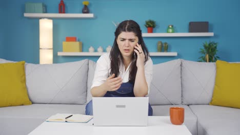 Mujer-Usando-Una-Computadora-Portátil-Hablando-Nerviosamente-Por-Teléfono.