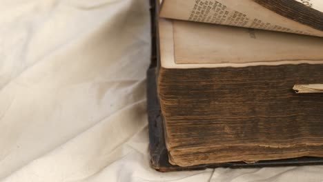 slow close-up pan of male hand turning pages in old heavy worn book