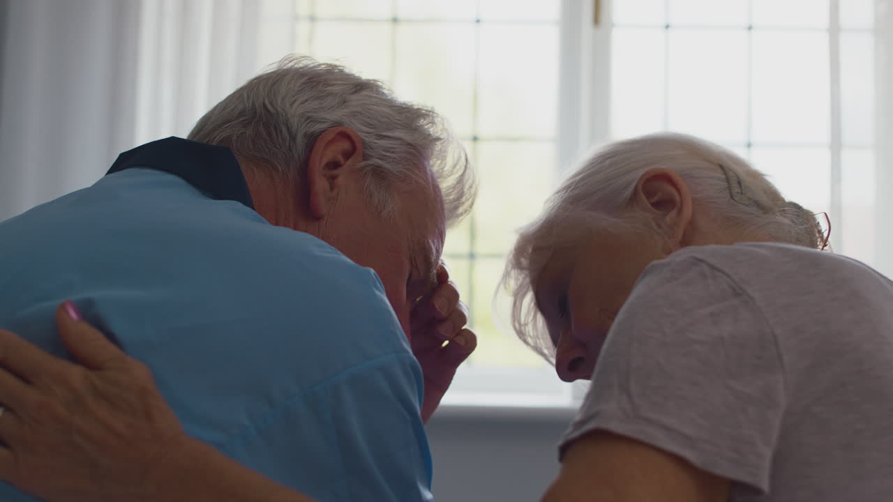 집 에서 침대 에 앉아 함께 이야기 하는 걱정 된 은퇴 한 노인 부부 의 클로즈업