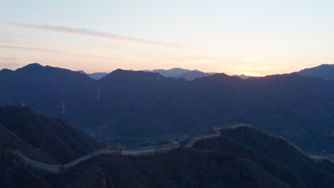 Aerial-Shot-of-The-Great-Wall-of-China-in-Mountains-at-Sunset