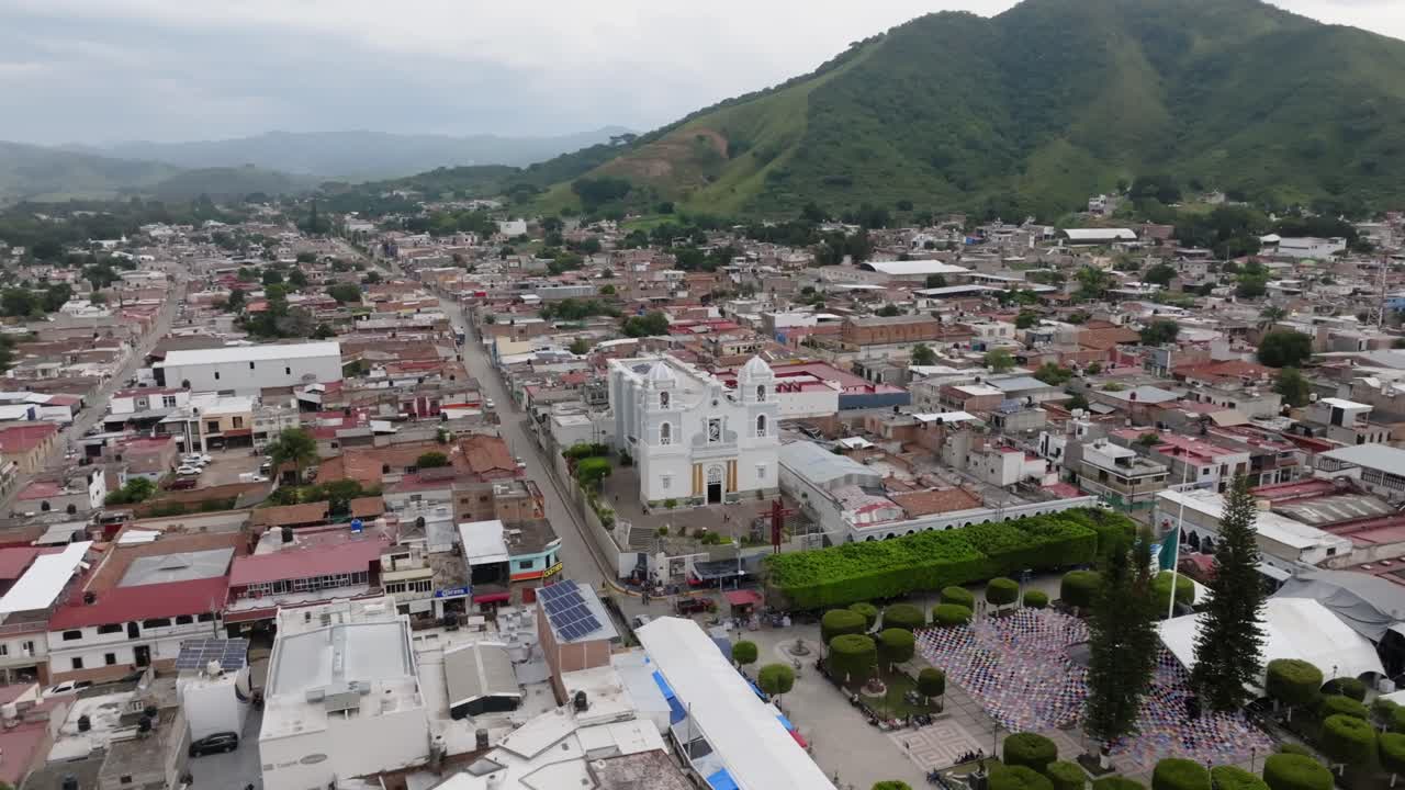Ripresa aerea di presentazione della città messicana di Tecalitlán, Jalisco, con una catena montuosa durante una giornata nuvolosa - ripresa in ascesa