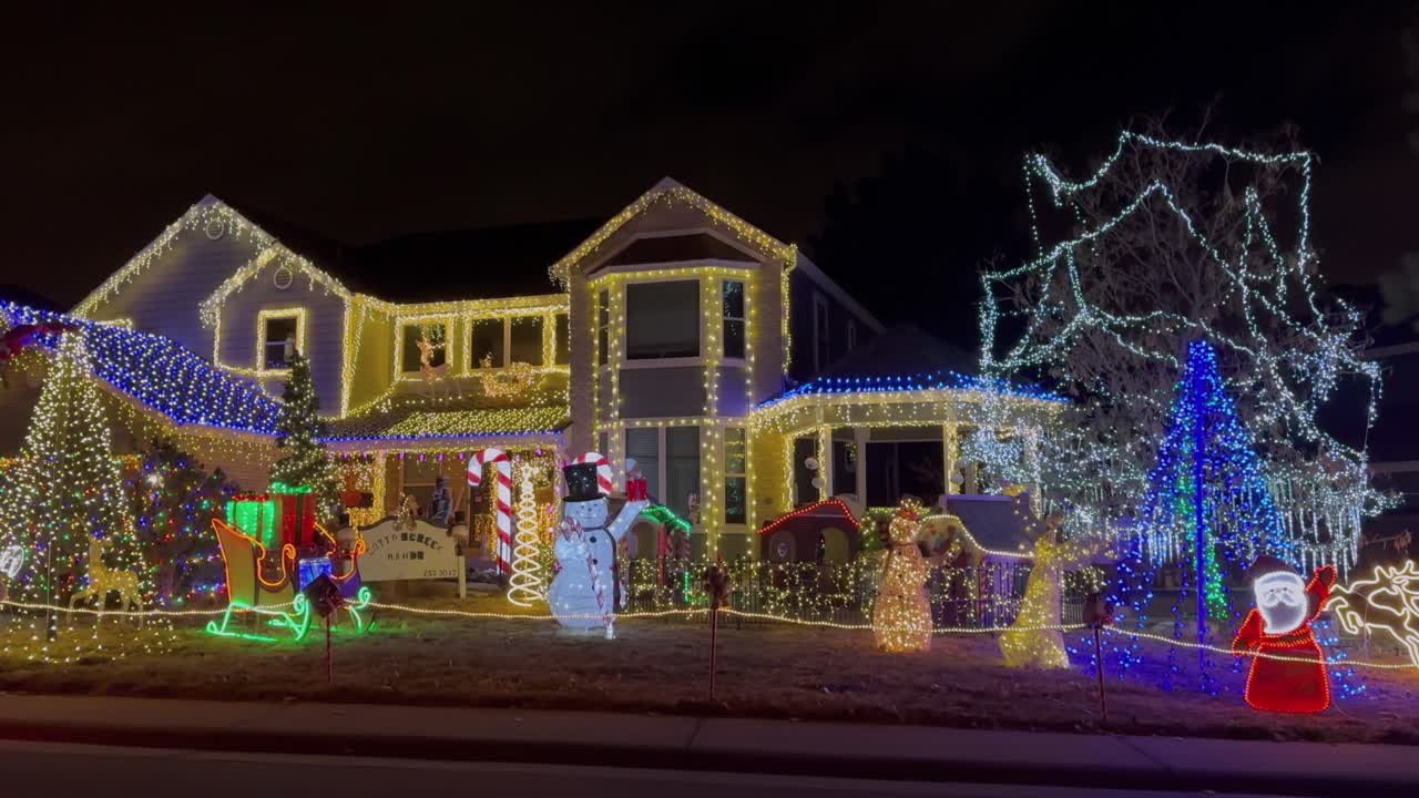 스노우맨 산타클로스 하우스 크리스마스 행복한 휴일 장식 하이랜드 랜치 덴버 콜로라도 미국 밤 시간 밝은 활기찬 불빛 집에 매달린 이웃 느린 팬 파랄락스 원 왼쪽 모션