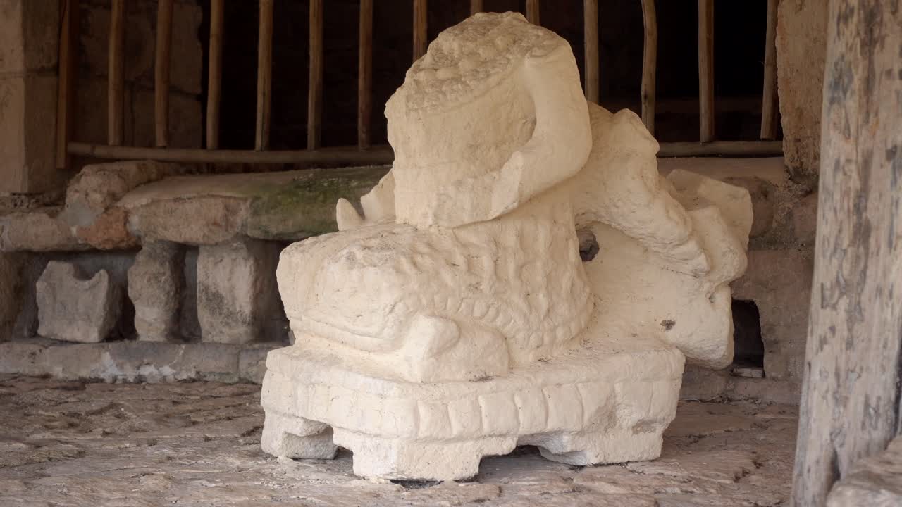 cámara moviéndose hacia la derecha mostrando un primer plano de la escultura intrincada de un guerrero en la acrópolis en el sitio arqueológico de ek balam en yucatán, méxico