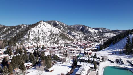 Drone-shot-flying-over-Red-River,-New-Mexico-on-a-sunny-winter-day