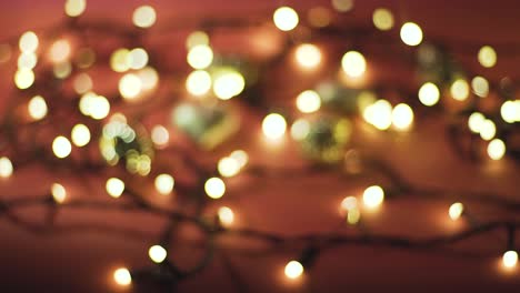 fotografía de cerca de la guirnalda con luces doradas y juguetes navideños en fondo de color. concepto navideño. decoración del hogar. hermoso bokeh
