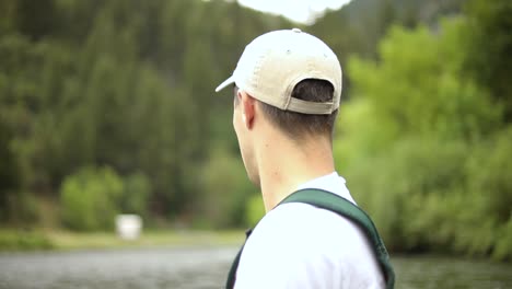 Shot-of-a-Caucasian-male-fisherman-casting-his-hook-while-Fly-Fishing