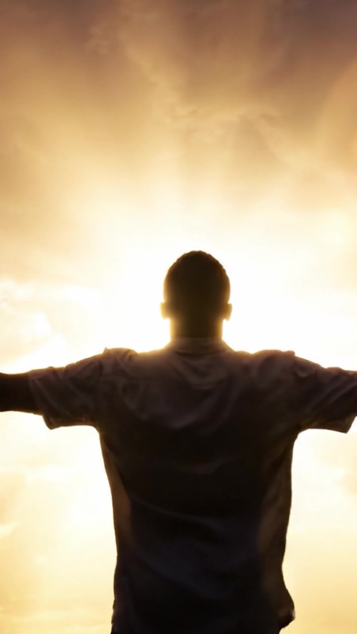 Una silueta contra un cielo radiante: abrazando el amanecer de nuevos comienzos y la belleza de la luz y la esperanza en un momento transformador.