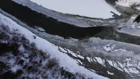 Frozen-River-In-Snowy-Landscape-With-Trees---Drone-Shot,-Rotating