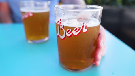 dos personas compartiendo cervezas en una mesa