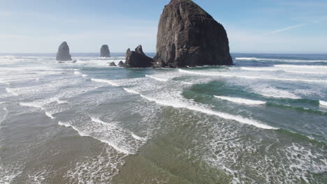 Ocean-waves-rush-past-Haystack-Rock-and-crash-onto-the-beach