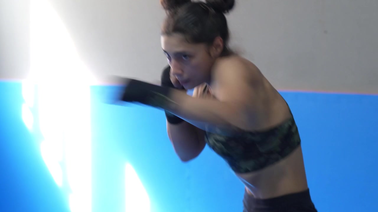 Uma mulher profissional está praticando boxe de sombra.