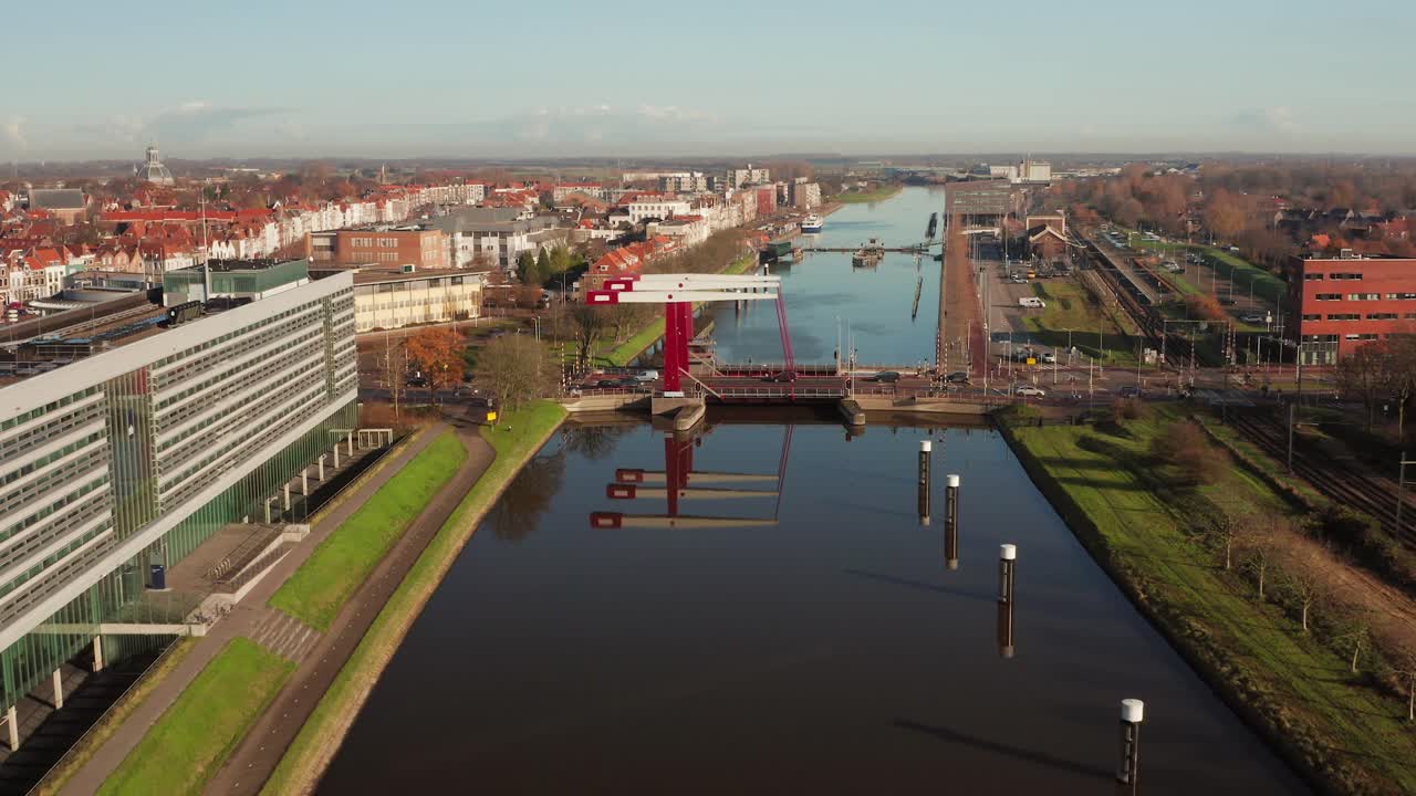 High angle aerial shot flying away from a busy bridge in the city of Middelburg