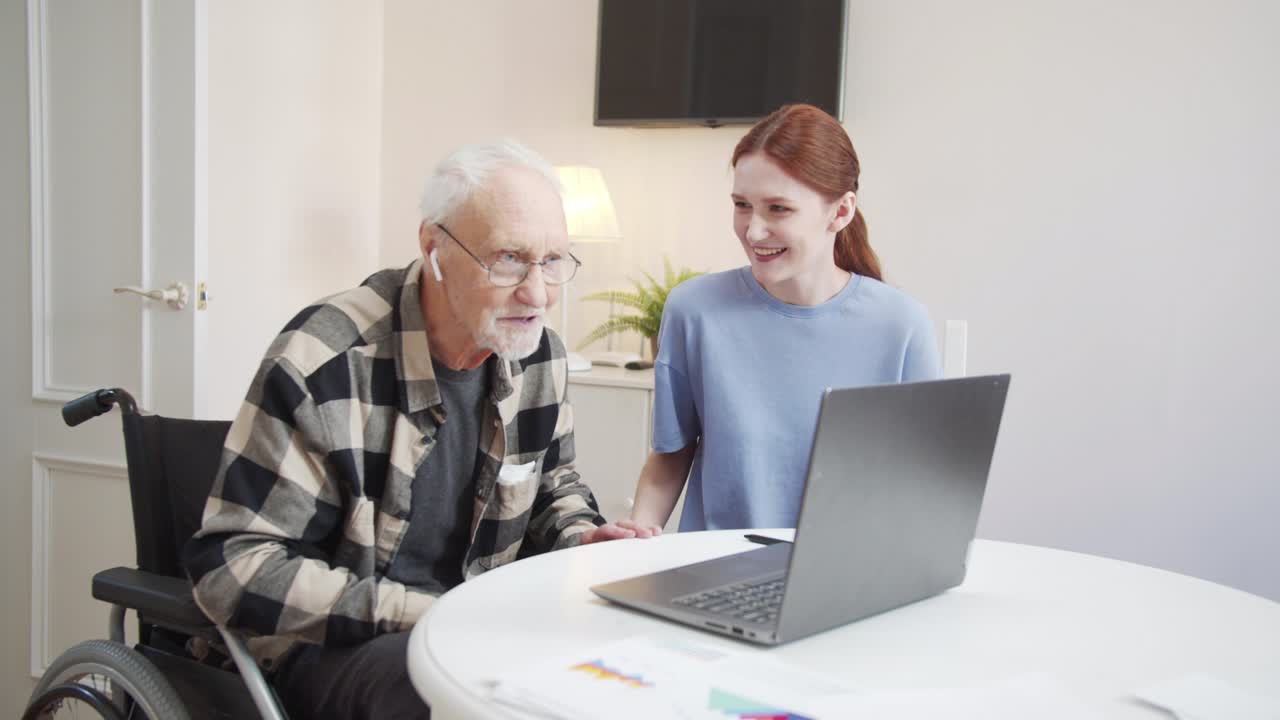 Grandpa in a wheelchair is delighted with wireless headphones