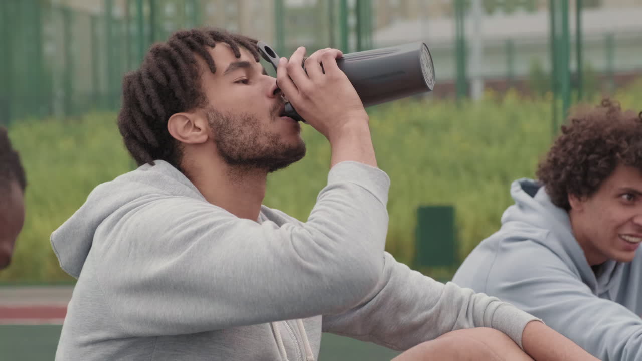 Happy Guys Resting after Basketball Game Outdoors